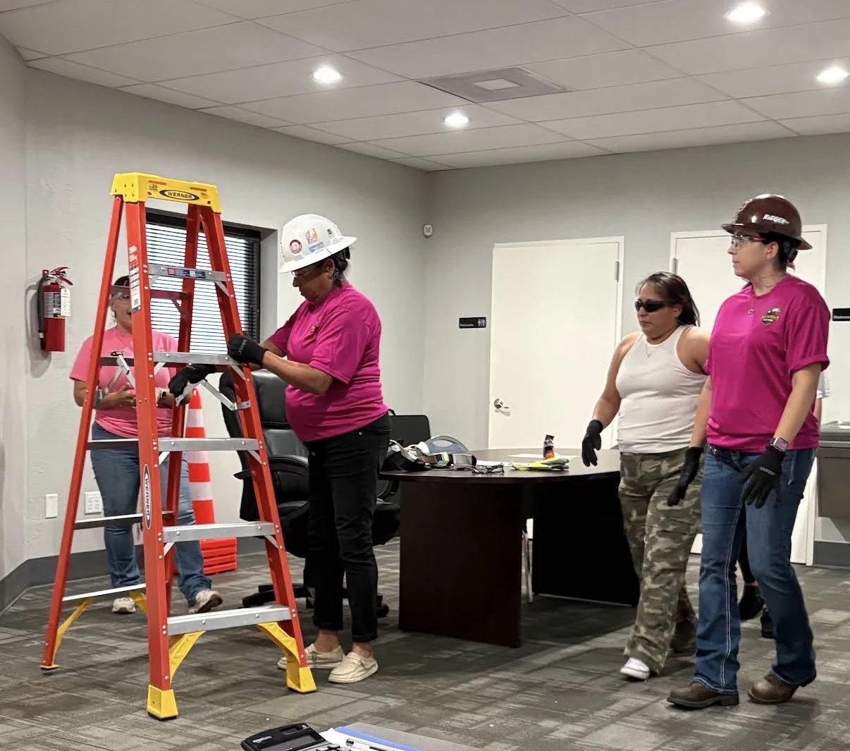 Safety students practicing ladder safety with hard hats and gloves